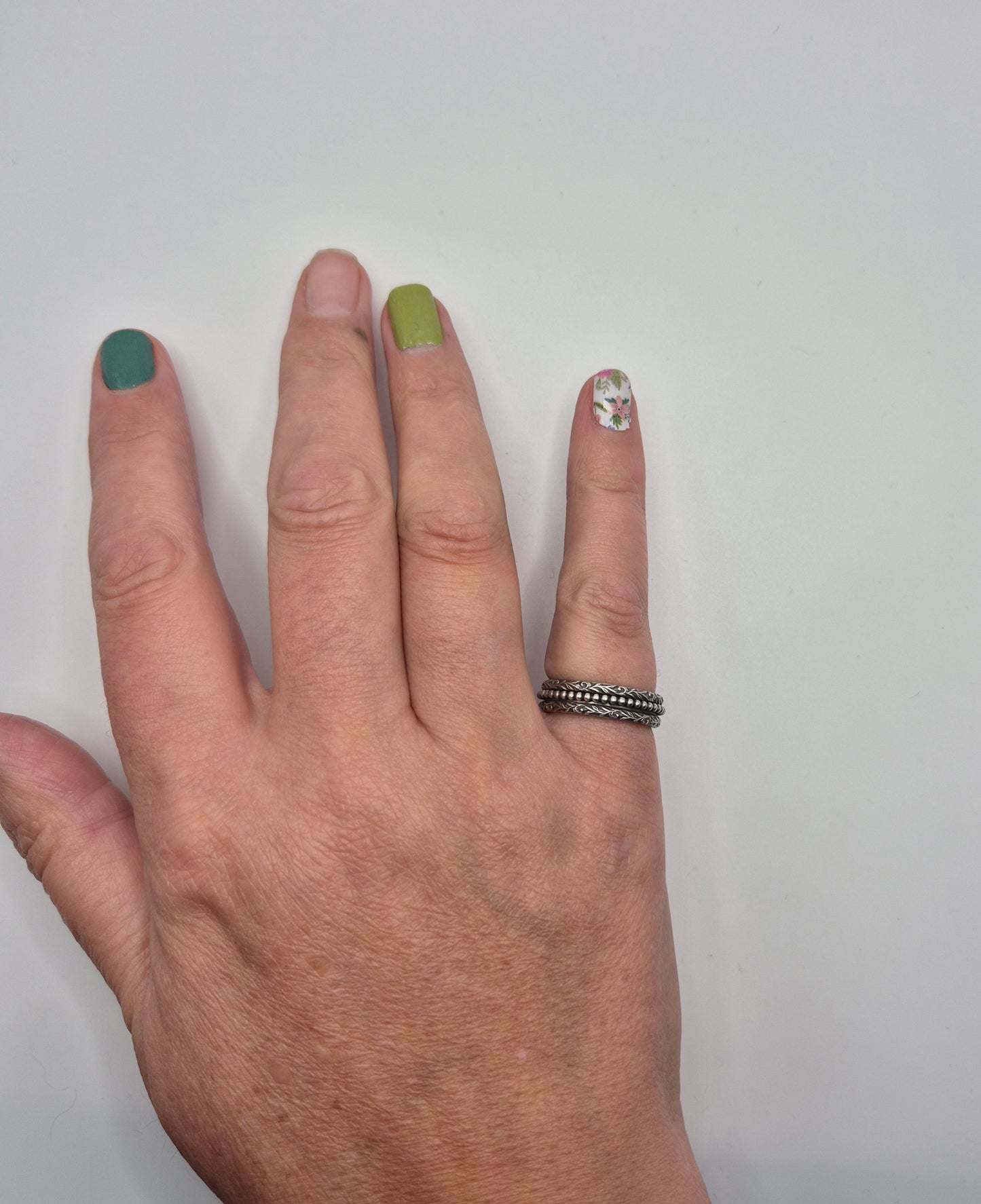 Sterling silver spinner ring worn on hand, showing decorative pattern detail