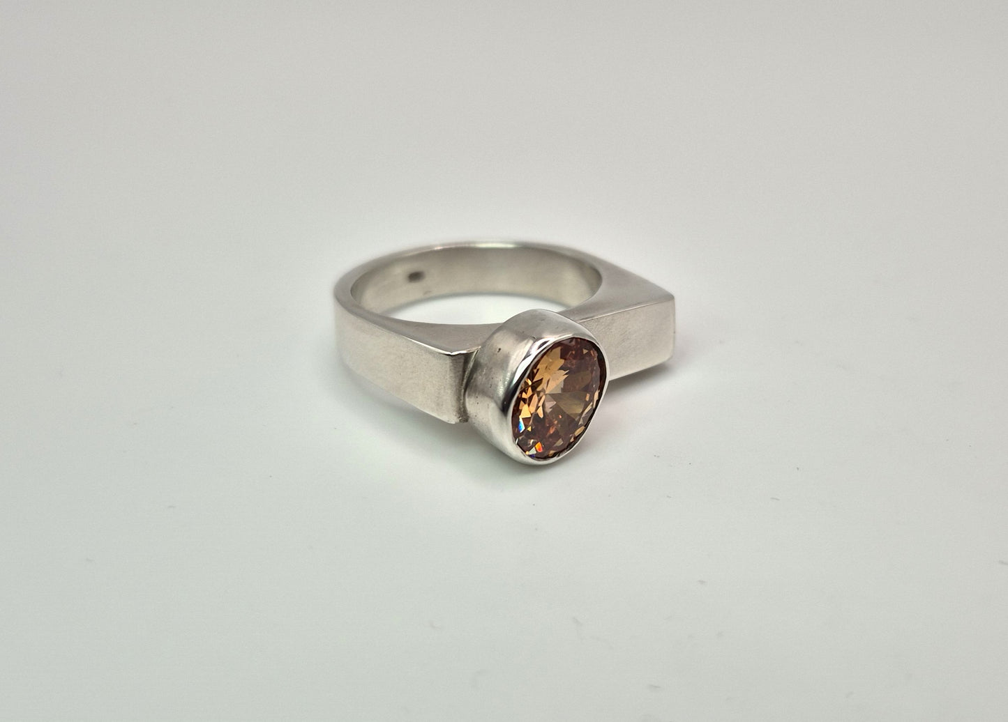 Sterling silver ring with champagne cubic zirconia stone on white background