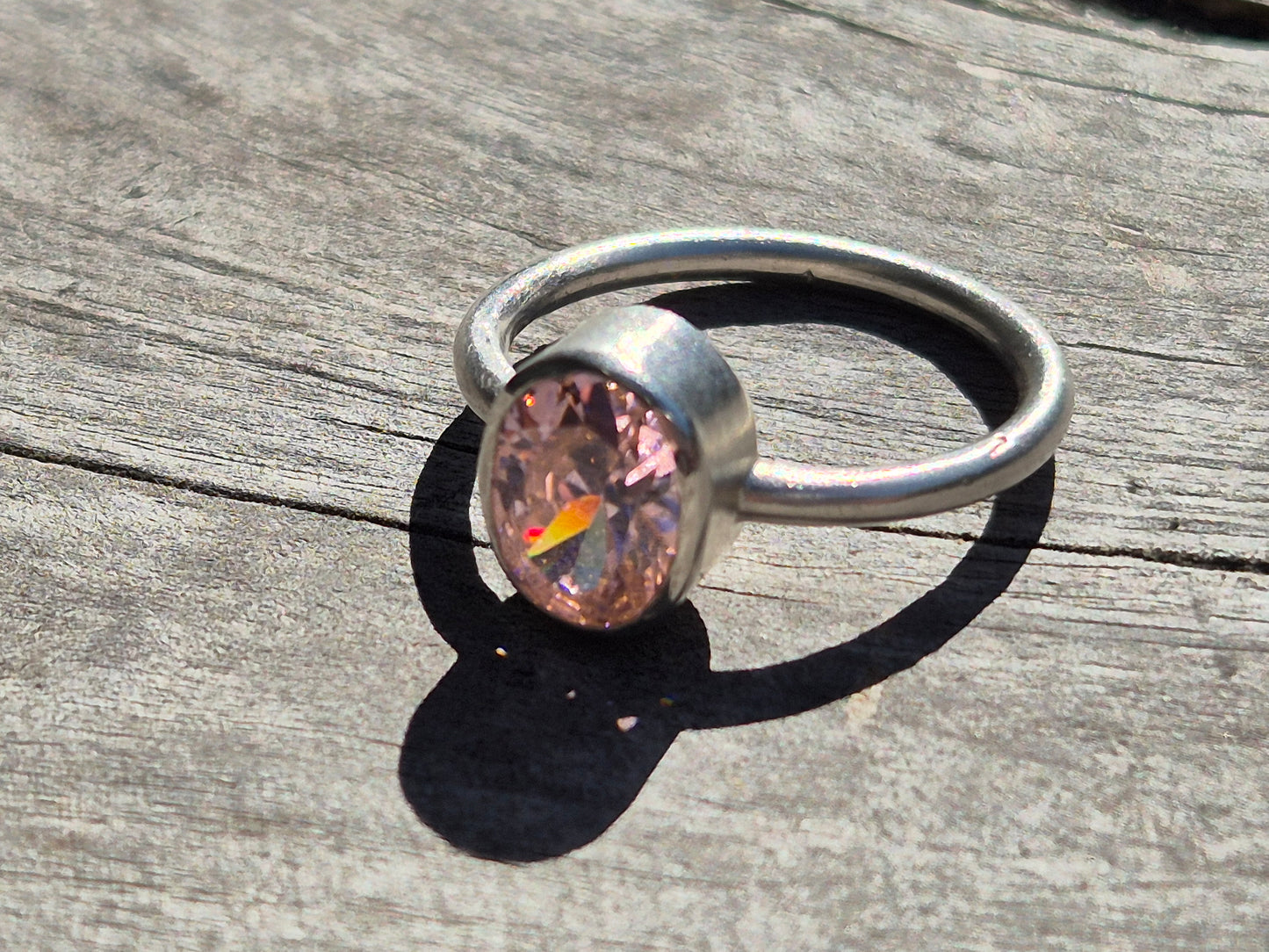 Close up of sterling silver ring with pink cubic zirconia stone