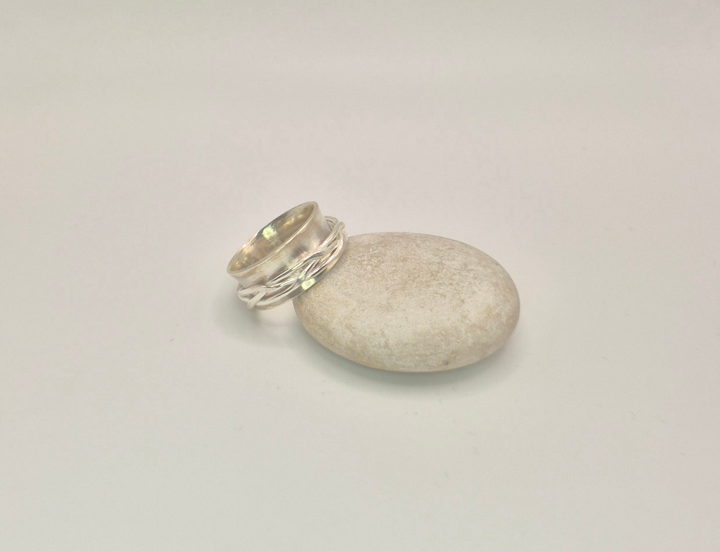 Side view of woven spinner ring showing 10mm width and curved anticlastic shape