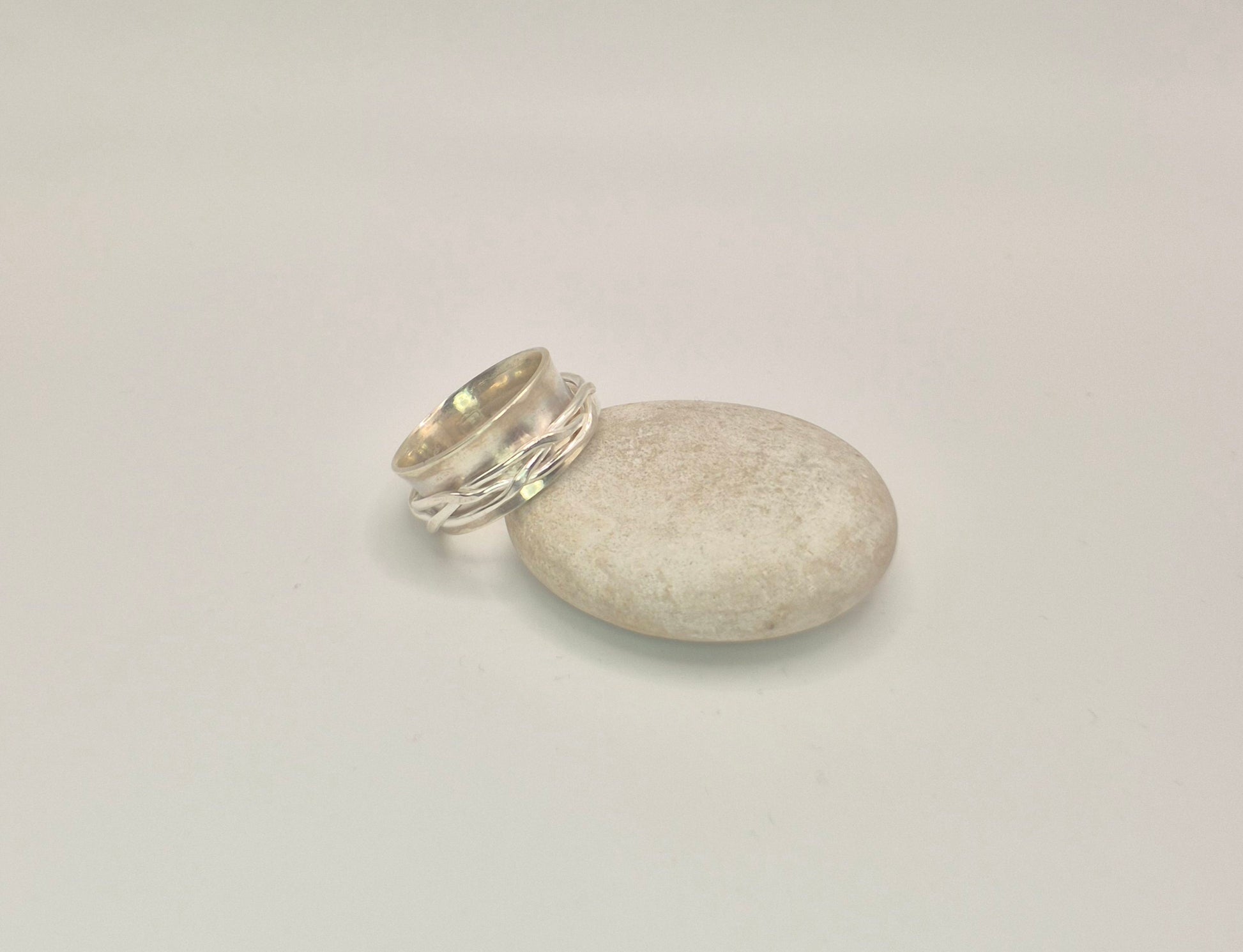 Side view of woven spinner ring showing 10mm width and curved anticlastic shape