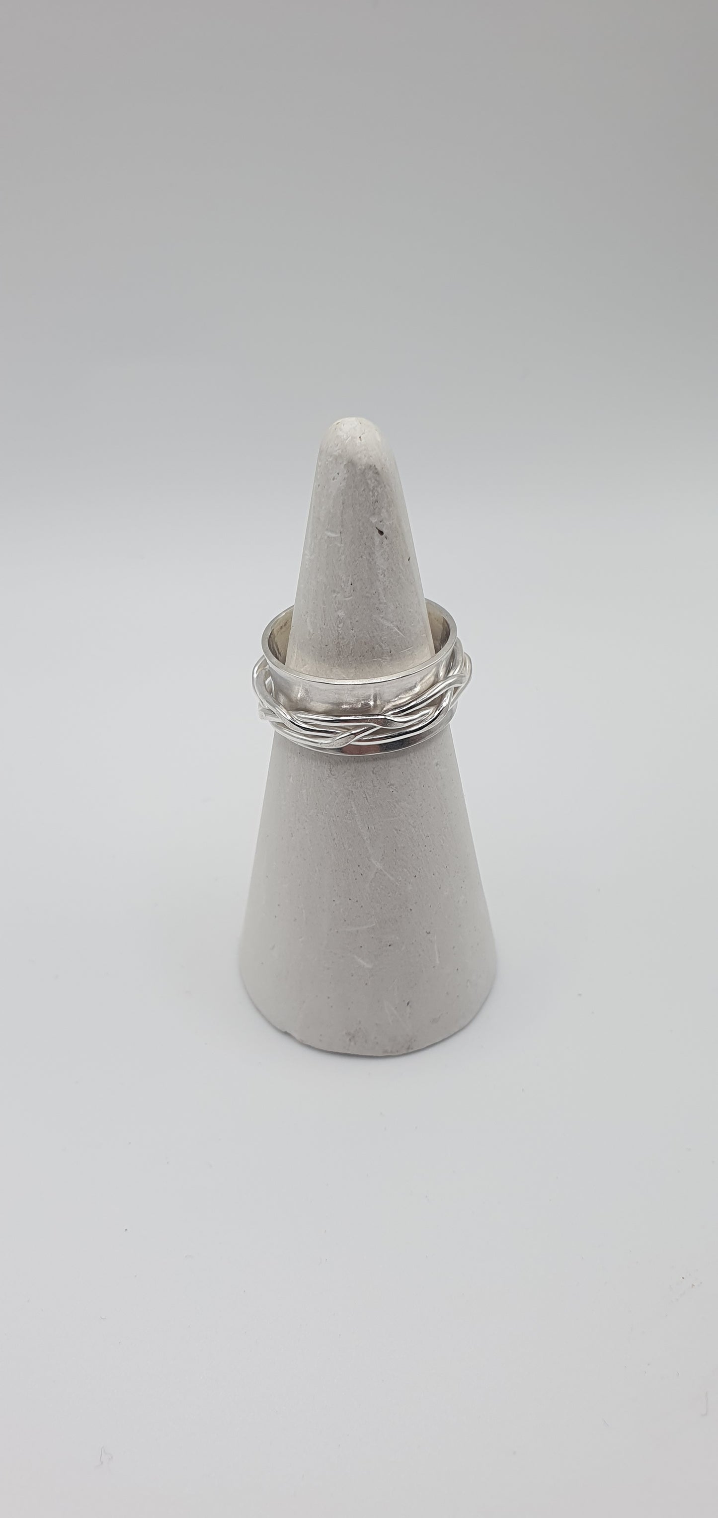 Woven spinner ring on white ring cone