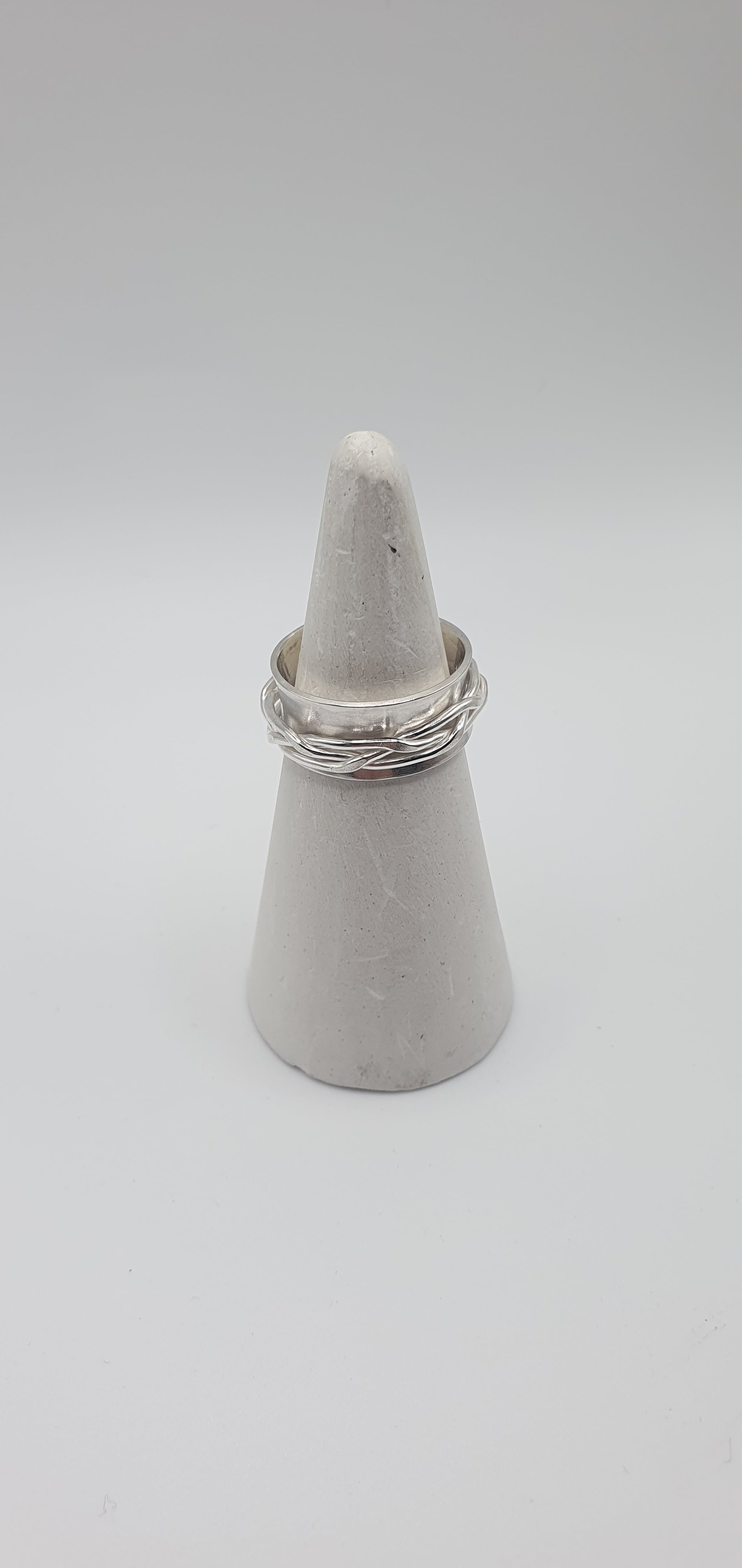 Woven spinner ring on white ring cone
